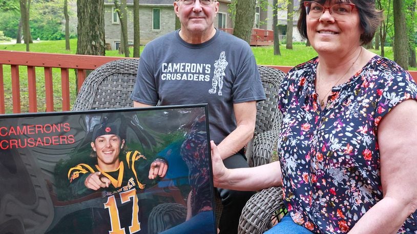 Dave and Karen Brucker with a picture of their son, Cameron, Monday, May 8, 2023. Cameron, a Shawnee graduate, died of a drug overdose in 2021. BILL LACKEY/STAFF