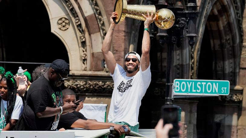 Boston Celtics' Jayson Tatum celebrates the team's NBA basketball championship during a duck boat parade Friday, June 21, 2024, in Boston. (AP Photo/Michael Dwyer)