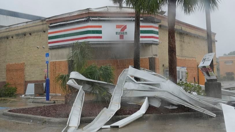 An apparent tornado caused by Hurricane Milton, tore the awning off a 7-Eleven convenient store, Wednesday, Oct. 9, 2024, in Cape Coral, Fla.(AP Photo/Marta Lavandier)