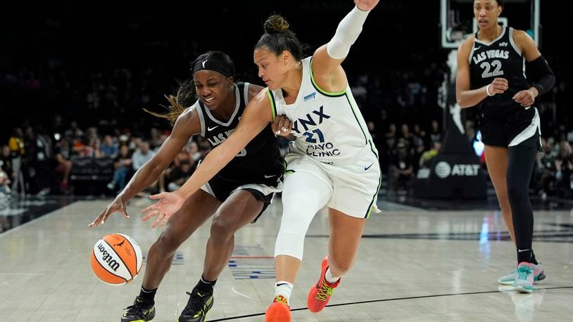 Minnesota Lynx guard Kayla McBride, right, guards Las Vegas Aces guard Jackie Young (0) during the first half of a WNBA basketball game Wednesday, Aug. 21, 2024, in Las Vegas. (AP Photo/John Locher)