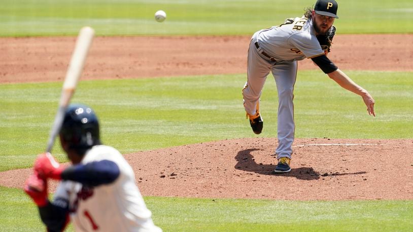 Pittsburgh Pirates' J.T. Brubaker, right, throws to an Atlanta Braves batter in the first inning of a baseball game Sunday, May 23, 2021, in Atlanta. (AP Photo/Tami Chappell)