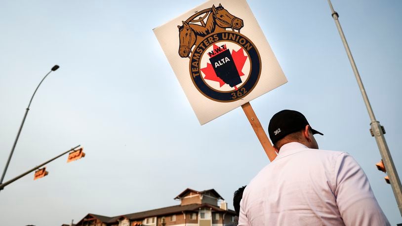 Teamsters Canada Rail Conference members picket outside the CPKC headquarters in Calgary, Alta., Friday, Aug. 23, 2024. (Jeff McIntosh/The Canadian Press via AP)