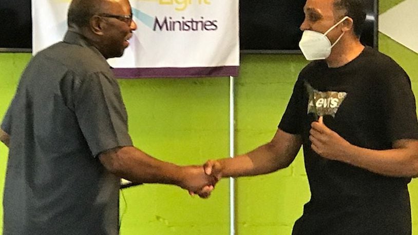 Urban Light Ministries CEO Eli Williams (left) congratulates James Wallace, one of 23 Community Fatherhood Award winners, at a ceremony in 2020. CONTRIBUTED