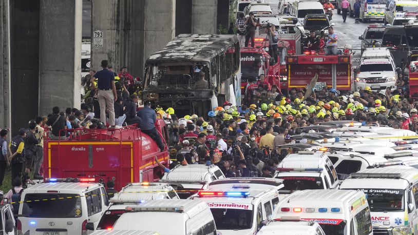 Rescuers gather at the site of a bus that caught fire, carrying young students with their teachers, in suburban Bangkok, Tuesday, Oct. 1, 2024. (AP Photo/Sakchai Lalit)