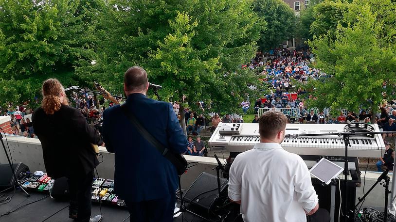 Hundreds of people gathered in National Road Commons Park in downtown Springfield for the Come Together Springfield 2023 - A Rooftop Beatles Tribute Friday, June 16, 2023. The Beatles tribute band played from the top of the city parking garage over looking the sea of music lovers that covered the park in their lawn chairs and blankets. The event, sponsored by Skyline Chili in conjuction with the Greater Springfield Partnership, also featured a variety of food trucks and refreshments. BILL LACKEY/STAFF