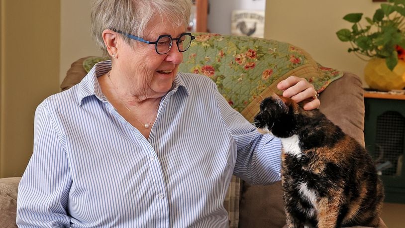 Judy Melvin, who is recovering from a heart attack, puts her cat Tuesday. BILL LACKEY/STAFF