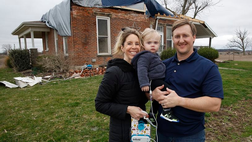 Jennifer and Seth Cosby are shown with their son John in front of their damaged house on South Buena Vista Road in Clark County Saturday, March 11, 2024. BILL LACKEY/STAFF