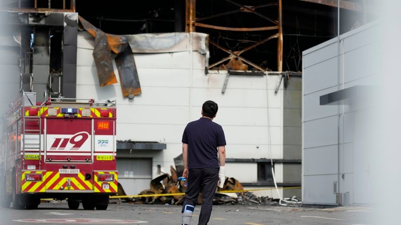 A man wearing a bandage on his right hand and a cast on left leg looks at the site of a burnt battery manufacturing factory in Hwaseong, South Korea, Tuesday, June 25, 2024. (AP Photo/Lee Jin-man)