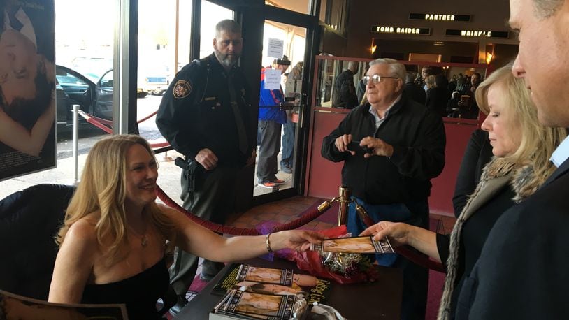 Actress Marsha Dietlein Bennett, a 1983 North High School graduate, autographs a photo on Friday, March 23 prior to a showing of her new film, “Getting Grace” at Chakeres Cinema 10. Photo by Brett Turner