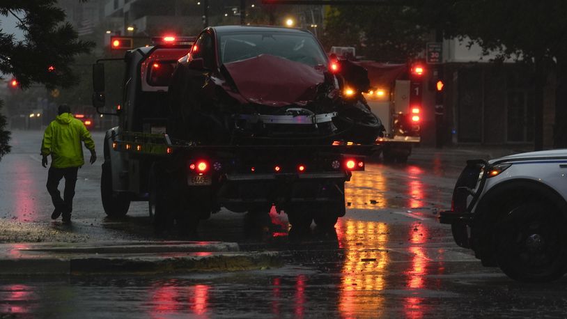 A tow truck responds following a traffic accident between a car and a fire truck returning from a call, on near-deserted streets in downtown Tampa, Fla., during the approach of Hurricane Milton, Wednesday, Oct. 9, 2024. (AP Photo/Rebecca Blackwell)