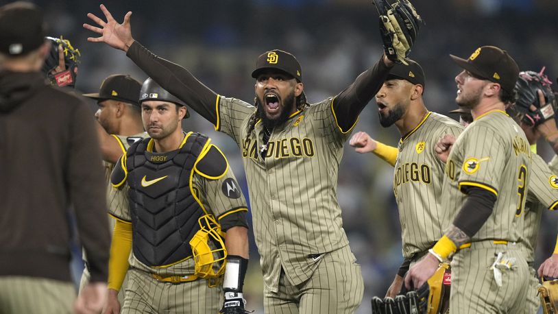 San Diego Padres' Fernando Tatis Jr., center, celebrates with teammates after the Padres clinched a playoff spot with a triple play to end their baseball game against the Los Angeles Dodgers, Tuesday, Sept. 24, 2024, in Los Angeles. (AP Photo/Mark J. Terrill)