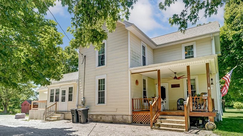 The house has a covered front porch with railings and a ceiling fan. It has updated vinyl siding and an unfinished basement.