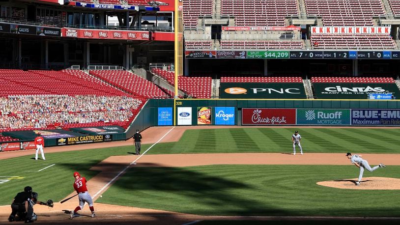 FILE - Cincinnati Reds' Jesse Winker, left, hits a single of a pitch thrown by Chicago White Sox' Garrett Crochet, right, during a baseball game in Cincinnati, Sunday, Sept. 20, 2020. (AP Photo/Aaron Doster, File)