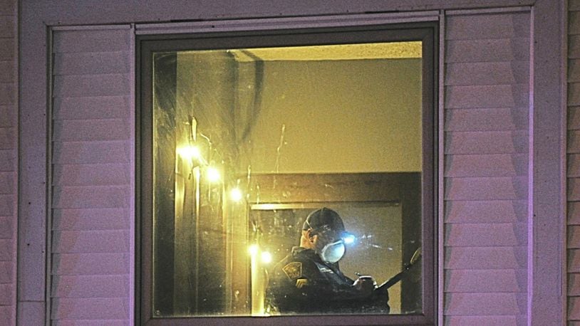 A member of Springfield Police Division investigates the scene of a double fatal shooting on the 900 block of Clinton Ave. late Monday. MARSHALL GORBYSTAFF