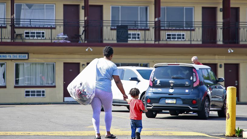 Toni Carter-White and her son carry their belongings as they leave the Executive Inn homeless shelter in Springfield on Tuesday, August 6, 2024. City Council voted the day before to reject a funding plan for the shelter. BILL LACKEY/STAFF