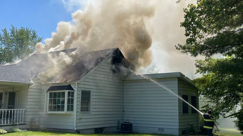 A Springfield Twp. firefighter works to extinguish a fire at a Springfield Twp. home at 2294 Seminole Avenue. BILL LACKEY/STAFF