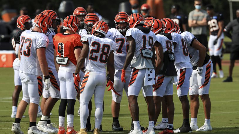 Cincinnati Bengals' Jonah Williams, left, Joe Burrow, middle left, Joe Mixon, middle, and Auden Tate, middle right, stand in team huddle during an NFL football camp practice in Cincinnati, Friday, Aug. 21, 2020. (AP Photo/Aaron Doster)