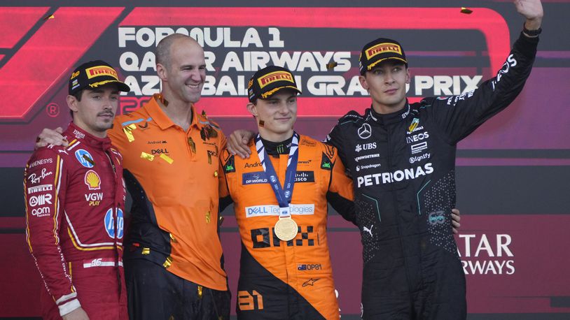 From the left, second-placed Ferrari driver Charles Leclerc of Monaco, McLaren's chief engineer Tom Stallard, first-placed McLaren driver Oscar Piastri of Australia, and third-placed Mercedes driver George Russell of Britain stand at the podium after the Formula One Grand Prix in Baku, Azerbaijan, on Sunday, Sept. 15, 2024. (AP Photo/Sergei Grits)