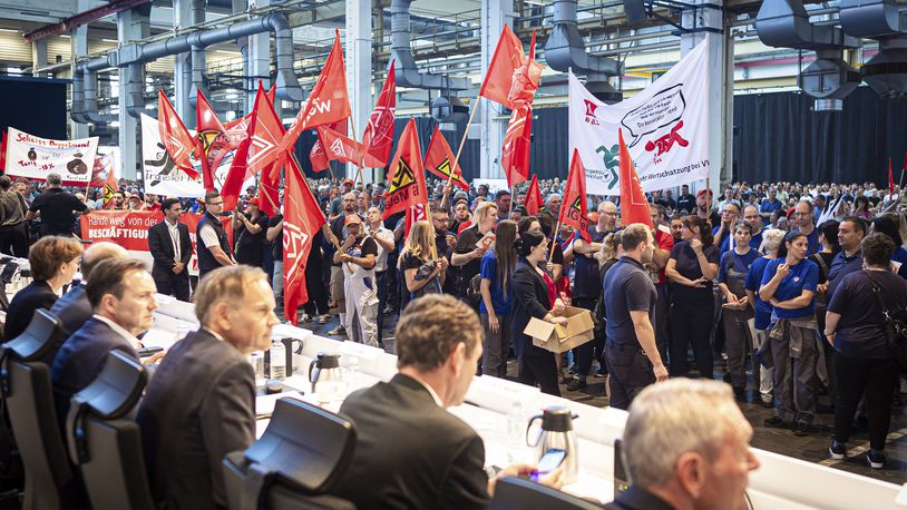 Employees protest before the start of a works meeting in a hall at the VW plant in Wolfsburg, Wednesday, Sept. 4, 2024. Volkswagen has announced that it will tighten its austerity measures due to the tense situation of the core brand. Redundancies and plant closures can no longer be ruled out. (Moritz Frankenberg/pool photo via AP)