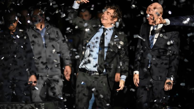 Argentine President Javier Milei, center, and National Deputy Jose Luis Espert celebrate at the end of a promotional event for Milei's new book in Buenos Aires, Argentina, Wednesday, May 22, 2024. (AP Photo/Gustavo Garello)