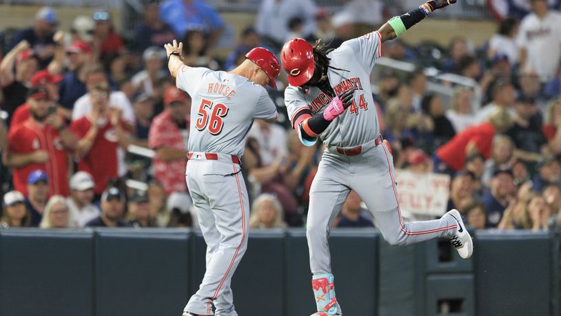 Cincinnati Reds Elly De La Cruz (44) celebrates with Cincinnati Reds third base coach J.R. House (56) after hitting a grand slam during the seventh inning of a baseball game against the Minnesota Twins, Friday, Sept. 13, 2024, in Minneapolis. (AP Photo/Nikolas Liepins)