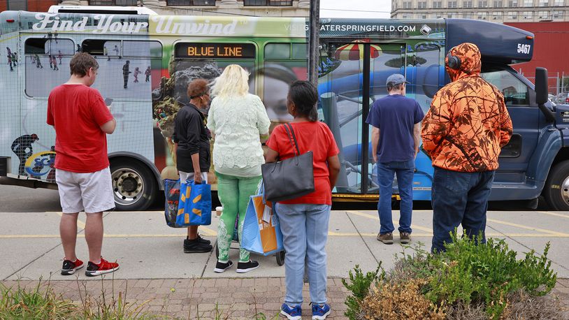 A group of people wait for their SCAT bus to arrive at the transit hub in downtown Springfield Thursday, August 15, 2024. BILL LACKEY/STAFF