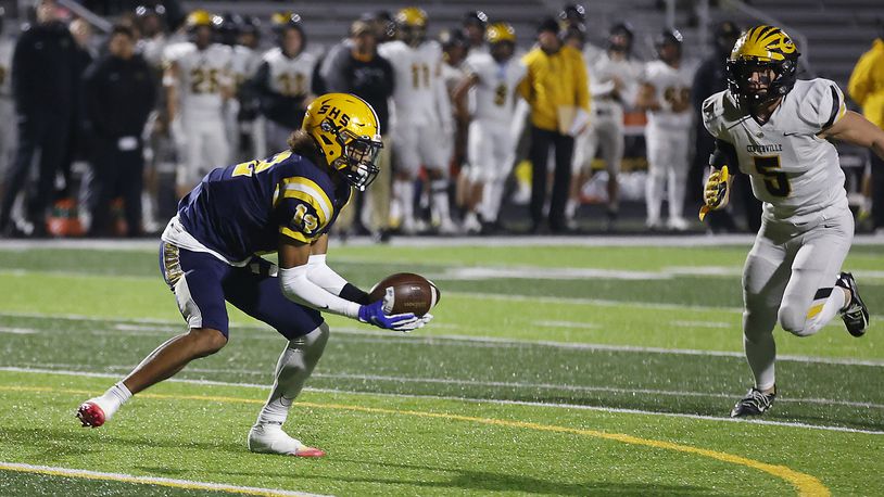 Da'Shawn Martin catches a pass as Centerville's Matthew Karpinsky moves in during Friday's playoff game. BILL LACKEY/STAFF