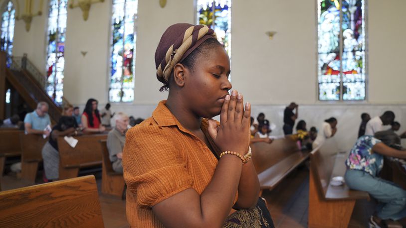 Marie Morette, a congregant of St Raphael Catholic church, prays during Mass in Springfield, Ohio, Sunday, Sept. 15, 2024. (AP Photo/Jessie Wardarski)