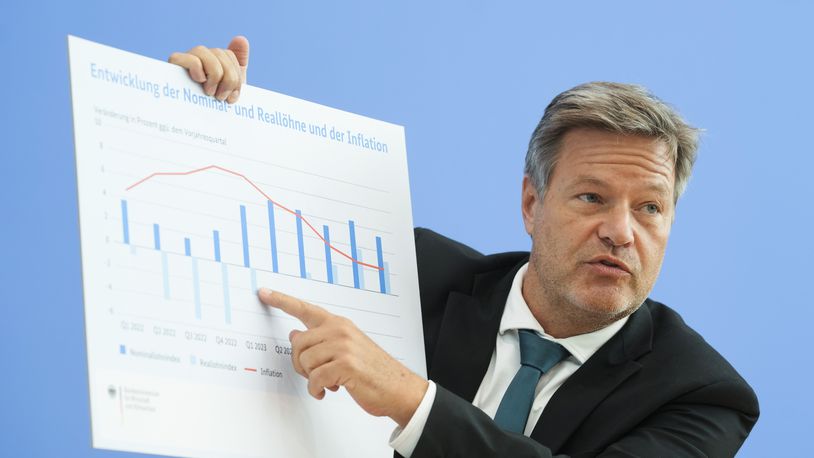 German Economy and Climate Minister Robert Habeck shows a cardboard with the development of nominal wages and real wages as well as inflation during a news conference of Germany's economy development in Berlin, Germany, Wednesday, Oct. 9, 2024. (AP Photo/Markus Schreiber)