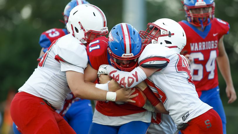 Southeastern High School junior C.J. Wilt (right) and junior Carson Bell (left) tackle Northwestern senior Brock Mansfield during their game on Friday night at Taylor Field in Springfield. The Trojans defense caused five turnovers as Southeastern won 41-7. CONTRIBUTED PHOTO BY MICHAEL COOPER