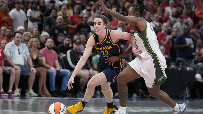 Indiana Fever's Caitlin Clark (22) goes to the basket against Seattle Storm's Jewell Loyd, right, during the first half of a WNBA basketball game, Sunday, Aug. 18, 2024, in Indianapolis. (AP Photo/Darron Cummings)