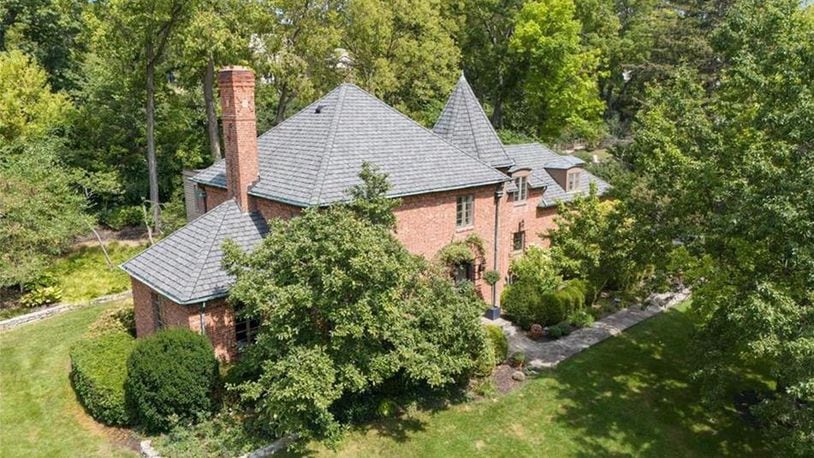 The brick French revival style home has been extensively updated and sits on a wooded lot within walking distance to Oakwood shops and schools