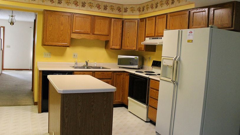 The kitchen boasts a movable island and plenty of wood cabinetry.