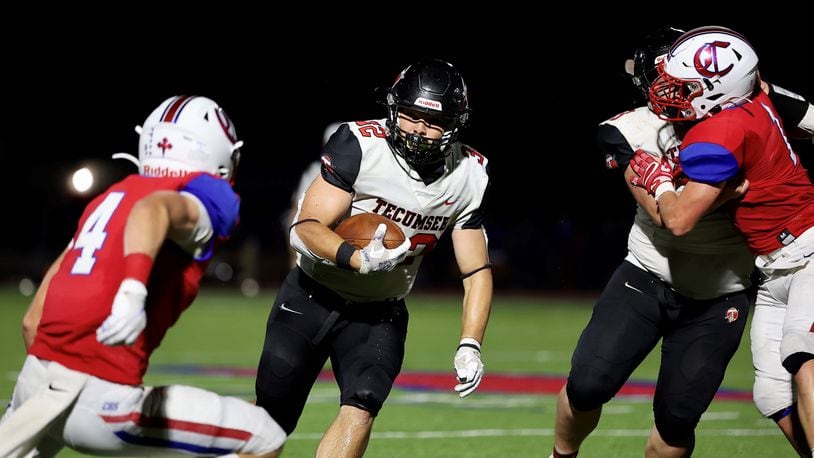 Tecumseh High School’s Josiah Botello runs past Carroll’s Charlie Harlow during their game on Friday night at Spoerl-Bartlett Field in Dayton. The Arrows won 42-14. CONTRIBUTED PHOTO BY MICHAEL COOPER