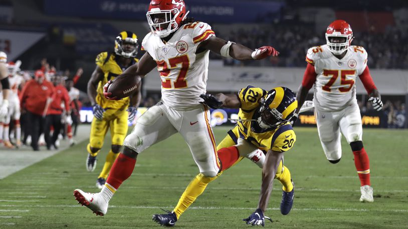 FILE - Kansas City Chiefs running back Kareem Hunt (27) scores a touchdown ahead of Los Angeles Rams free safety Lamarcus Joyner (20) as Chiefs offensive guard Cameron Erving (75) looks on during the first half of an NFL football game, Monday, Nov. 19, 2018, in Los Angeles. (AP Photo/Marcio Jose Sanchez, File)