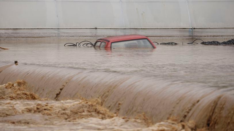 A car is submerged in flood waters outside an apartment building in the village of Kiseljak, northern Bosnia, Friday, Oct. 4, 2024. (AP Photo/Armin Durgut)