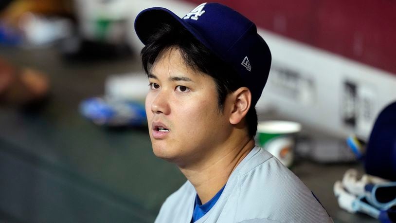 Los Angeles Dodgers' Shohei Ohtani, of Japan, sits in the dugout during the seventh inning of a baseball game against the Arizona Diamondbacks, Sunday, Sept. 1, 2024, in Phoenix. (AP Photo/Ross D. Franklin)