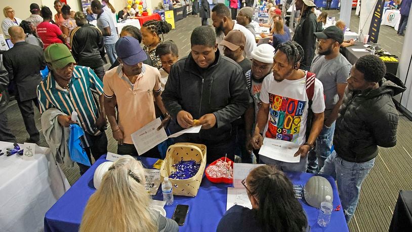 Members of Springfield's Haitian community gather around Bradley Jean, center, as he translates for them at the Topre America booth during the 14th Annual Clark County Job Fair Wednesday, April 17, 2024. The job fair featured 60 employers looking for skilled and unskilled workers.  BILL LACKEY/STAFF