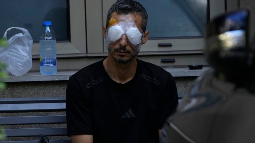 A man who was injured in the explosion of one of the handheld devices, sits outside the Eye Specialist hospital, in Beirut, Lebanon, Friday, Sept. 20, 2024. (AP Photo/Hussein Malla)