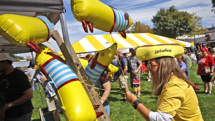 Meighan Schutte gets a wiener dog balloon for a customer during MustardFEST Saturday, Sept. 16, 2023. BILL LACKEY/STAFF