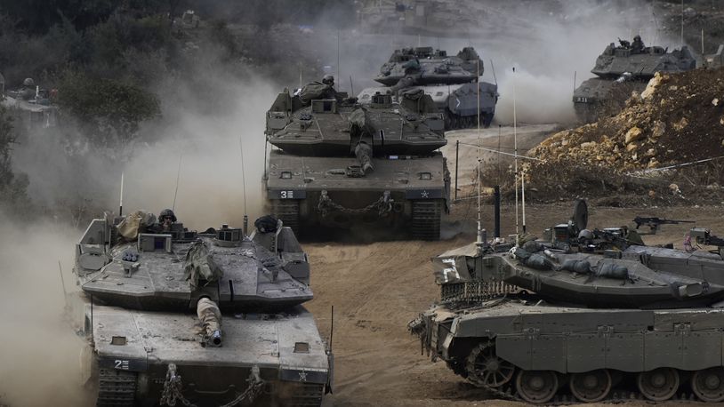 Israeli army tanks manoeuvre in a staging area in northern Israel near the Israel-Lebanon border, Tuesday, Oct. 1, 2024. (AP Photo/Baz Ratner)