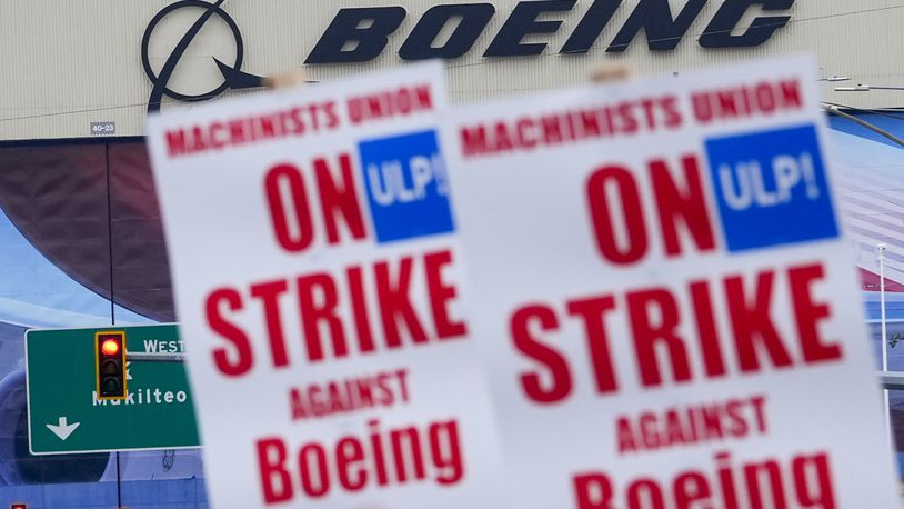 Boeing workers wave picket signs as they strike after union members voted to reject a contract offer, Sunday, Sept. 15, 2024, near the company's factory in Everett, Wash. (AP Photo/Lindsey Wasson)