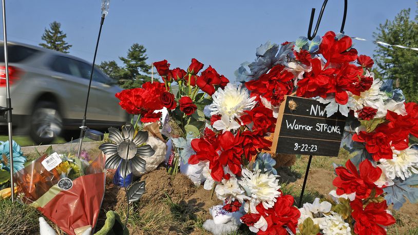 A memorial has started to form Wednesday, August 23, 2023 along Troy Road at the site of Tuesday's fatal bus crash. BILL LACKEY/STAFF