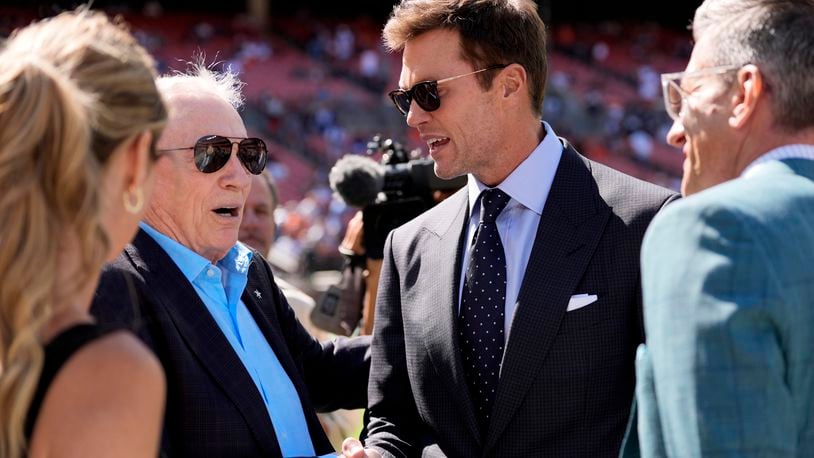 Dallas Cowboys team owner Jerry Jones, left, and analyst Tom Brady, center right, talk with others during team warmups before an NFL football game against the Cleveland Browns in Cleveland, Sunday, Sept. 8, 2024. (AP Photo/Sue Ogrocki)