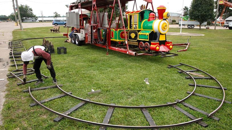 Workers from Durant Amusements unload the train ride on the midway at the Clark County Fairgrounds Tuesday, July 9, 2024. The Clark County Fair starts in 10 days. BILL LACKEY/STAFF