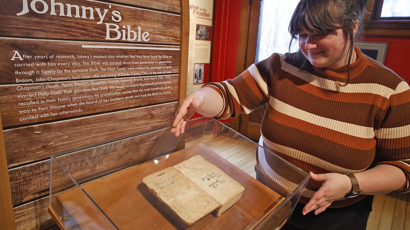 Mikaela Prescott, Johnny Appleseed museum director, looks over the Bible that John Chapman carried, now on display at The Johnny Appleseed Educational Center & Museum in Urbana. The renovated museum will be opening on Nov. 28 after being closed for three and a half years. BILL LACKEY/STAFF