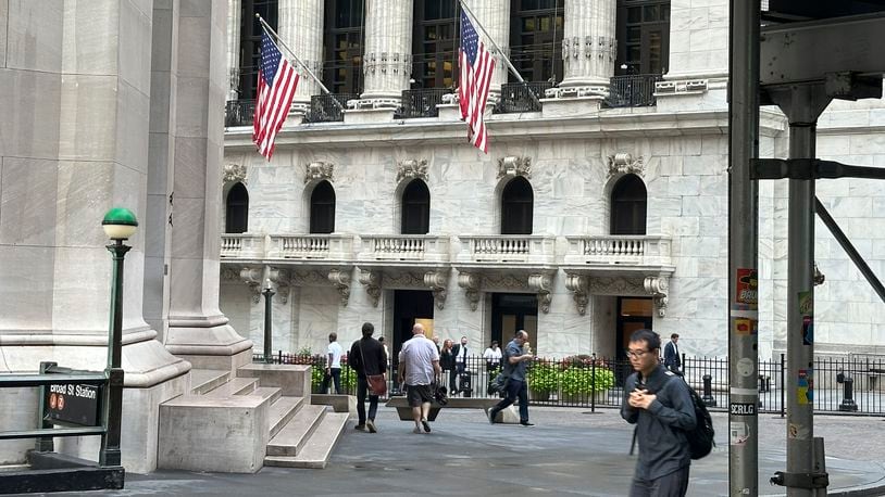 FILE - People pass the New York Stock Exchange, at rear, on Aug. 27, 2024, in New York. (AP Photo/Peter Morgan, File)