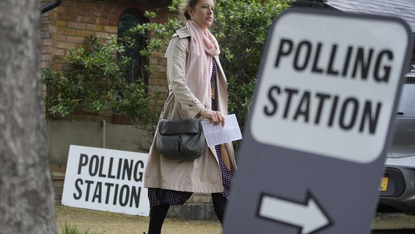 FILE - A woman holds her voting card as she arrives to vote in London in local elections, Thursday, May 2, 2024. U.K. voters are set to cast ballots in a national election on July 4, passing judgment on 14 years of Conservative rule. They are widely expected to do something they have not done since 2005 — elect a Labour Party government. (AP Photo/Kin Cheung, File)