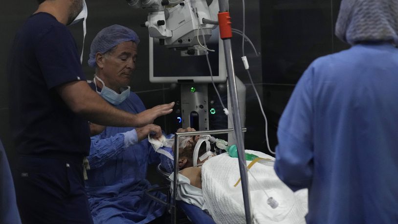 Elias Jaradeh, a legislator and an ophthalmologist, center, who has conducted dozens of operation for victims of this week's attack in Lebanon, makes an eye surgery operation for a man who was injured in the explosion of one of the handheld devices, at the Eye Specialist hospital, in Beirut, Lebanon, Friday, Sept. 20, 2024. (AP Photo/Hussein Malla)