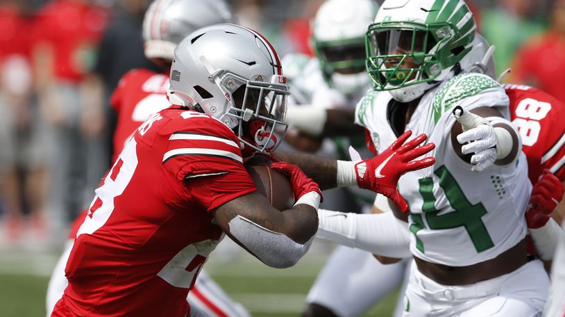 Ohio State running back Miyan Williams, left, tries to run past Oregon defensive lineman Bradyn Swinson during the first half of an NCAA college football game Saturday, Sept. 11, 2021, in Columbus, Ohio. Oregon beat Ohio State 35-28. (AP Photo/Jay LaPrete)